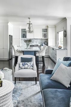 a living room filled with furniture next to a kitchen