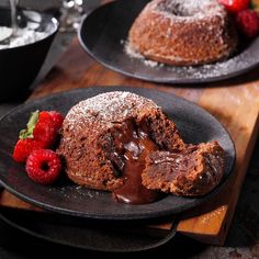 chocolate bundt cake and raspberries on two black plates