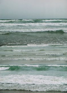 two surfers walking into the ocean with their surfboards