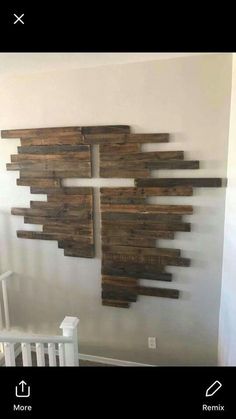 a wooden wall hanging on the side of a white wall next to a baby crib