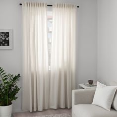 a living room with a white couch and curtains