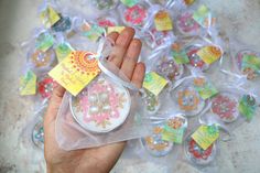 a hand holding a small glass ornament with colorful designs on it's side