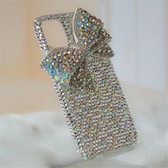 an image of a cell phone case that is covered in sequins and has a bow on it