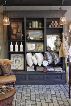 a living room filled with furniture and lots of pillows on top of it's shelves