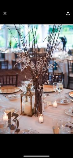 a centerpiece with flowers and candles on a table