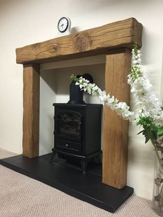 an old fashioned wood burning stove in a room with white flowers on the floor and a clock above it