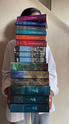 a person holding a stack of books in front of their face