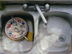 a dirty sink with dishes and utensils in it