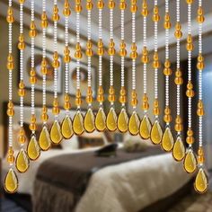 a bed room with a neatly made bed and lots of beads hanging from the ceiling