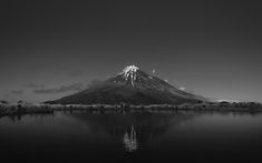 a black and white photo of a mountain in the distance