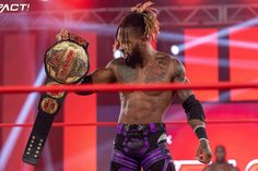 a man with dreadlocks holding up a wrestling belt