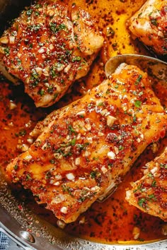 four pieces of meat in a pan with sauce and seasoning on the side, ready to be cooked