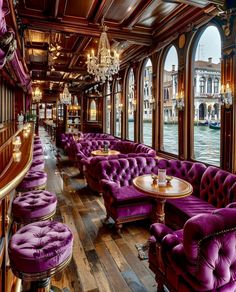 the interior of a restaurant with purple couches and chandeliers