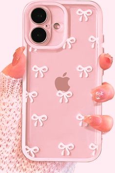 a woman holding up an iphone case with bows on the front and back cover in pink