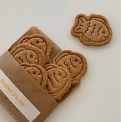 some cookies are in a box on a white surface with a sticker that says happy pigie