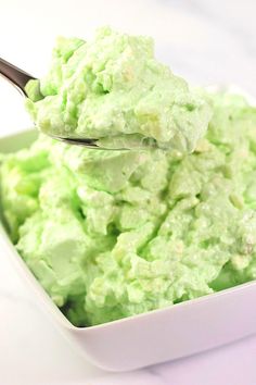 a spoon full of ice cream sitting in a bowl