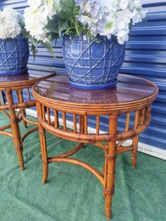 two blue vases sitting on top of a wooden table next to each other with flowers in them