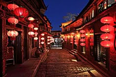 an alley with lanterns lit up at night