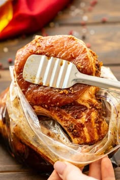 a person holding a plastic spatula over some food