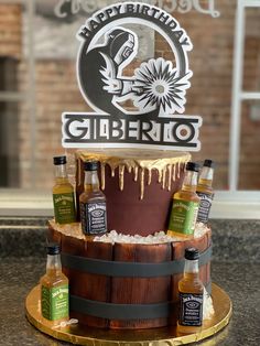 a birthday cake made to look like a barrel with liquor bottles on it and the name happy birthday giberno