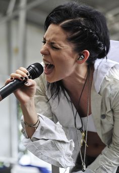 a woman singing into a microphone on stage