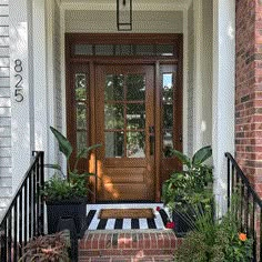 the front door of a house with potted plants