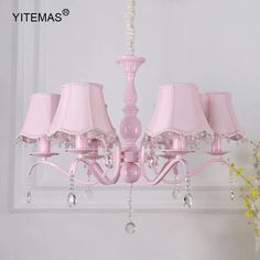 a pink chandelier hanging from a ceiling with four lamps on top of it