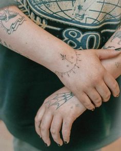 a woman with tattoos on her arm and wrist