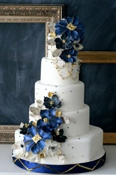 a white and blue wedding cake with flowers on it