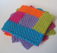 multicolored crocheted dishcloths stacked on top of each other