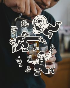 a man holding a glass with some stickers on it