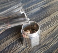 an empty glass bottle sitting on top of a wooden table