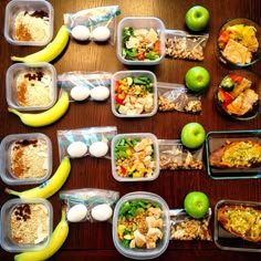 several plastic containers filled with food on top of a wooden table next to green apples and bananas