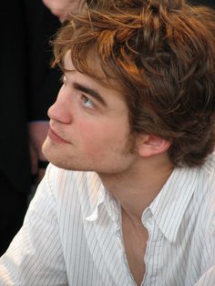 a black and white photo of a man with curly hair looking off to the side