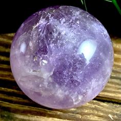 a purple ball sitting on top of a wooden table