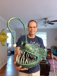 a man holding a fake dinosaur head in his hands