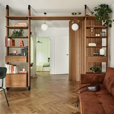 a living room filled with furniture next to a wooden table and bookshelf on top of a hard wood floor