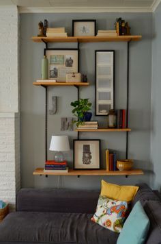 a living room filled with furniture and bookshelves next to a wall mounted shelf