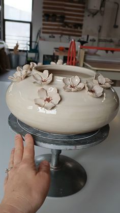 a person is holding onto a cake plate with flowers on it