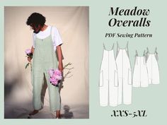 a woman in overalls holding flowers and standing next to a white backdrop with the words medosa overalls on it