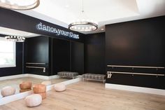 an empty dance studio with black walls and wooden floors