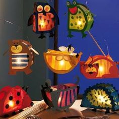 some paper cut out animals and lights on a table next to a window with blue sky in the background