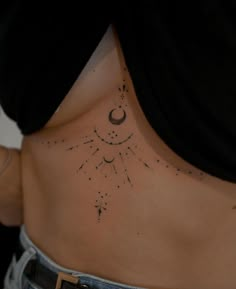 a woman's lower back with stars and moon tattoos on her left side ribcage