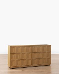 a large wooden dresser sitting on top of a hard wood floor next to a white wall