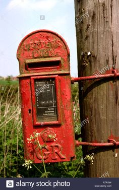 an old red mailbox attached to a telephone pole