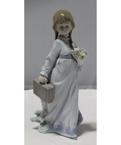 a figurine of a girl holding a suitcase and flowers in her left hand