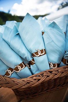 a basket filled with blue napkins on top of a wooden table