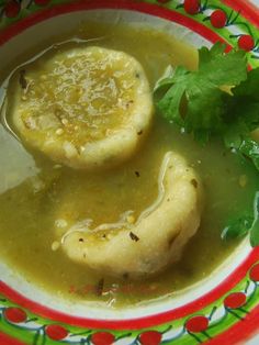 a bowl filled with soup and two dumplings