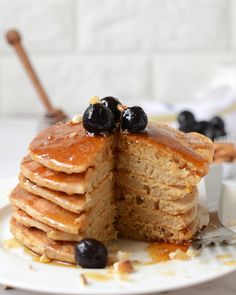 a stack of pancakes topped with blueberries and syrup