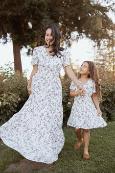 Frolicking in flower fields will be the norm when you wear the Michaela Dress. This dress features a vintage-inspired floral pattern against a neutral shade appropriate for any occasion. Its tiered, full-length skirt and cap sleeves provide coverage, while the flattering, surplice neckline keeps you cool on summer evenings. The best part? It's also available for kids, allowing you and your daughter to spend the day twinning! STYLE INFO & CARE Smocked Waist Tiered Skirt Fully lined 100% Polyester Machine washable in cold water Mom And Daughter Dress, Daughter Dress, Matching Outfit, Full Length Skirts, Mom And Daughter, Holiday Dress, Dress Boho, Tier Skirt, Flower Field